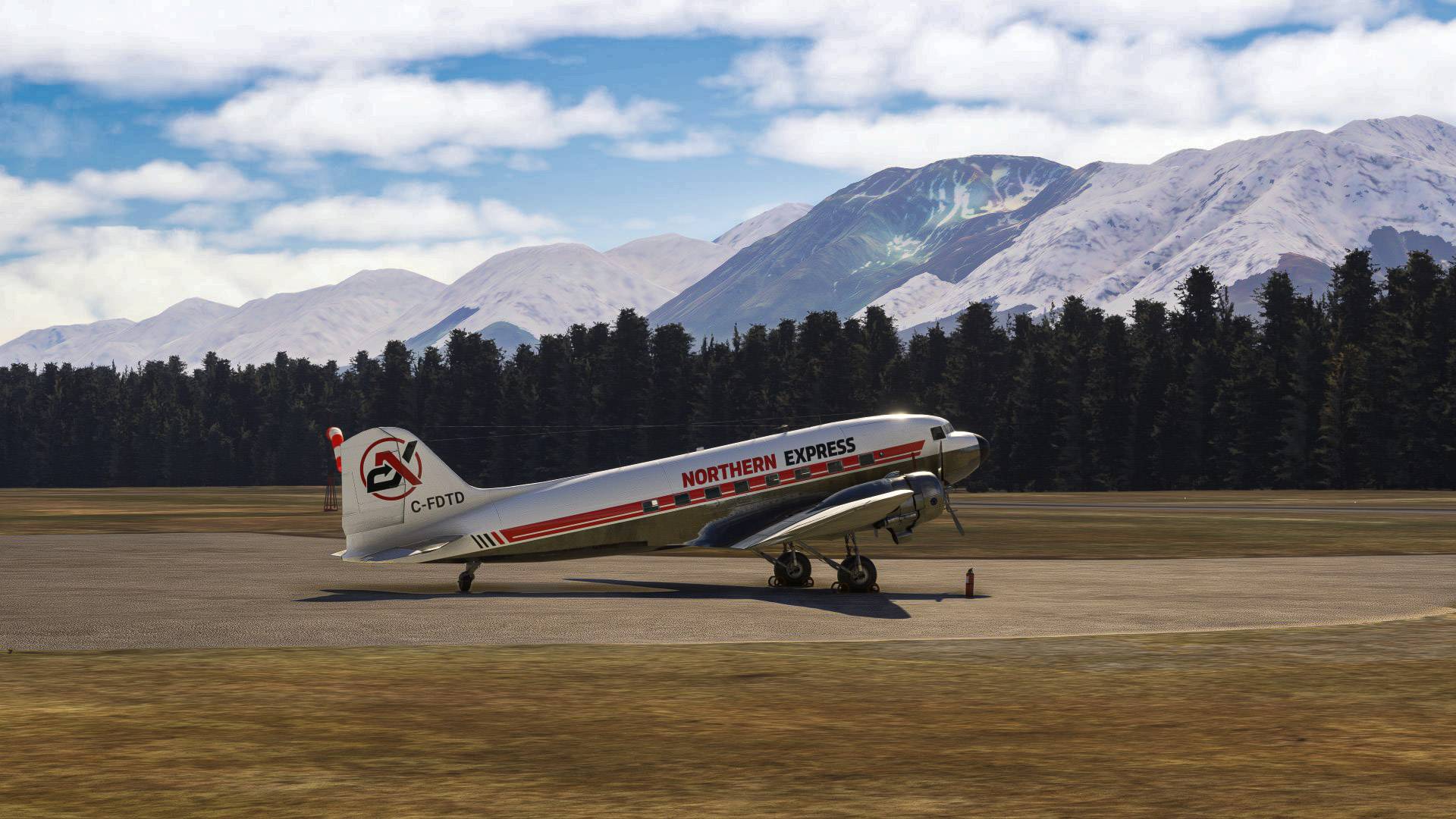 Douglas DC-3 on a runway with mountains behind